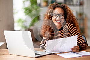 Happy young african american woman smiling at camera while working remotely studying online from home