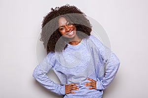 Happy young african american woman standing with hands on hips against white background