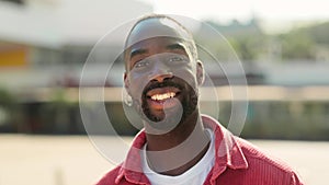 Happy young African Black man standing on street looking at camera. Portrait