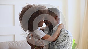 Happy young african ethnicity father cuddling little cute daughter.