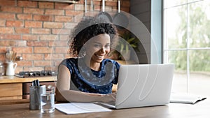 Happy young african ethnicity multiracial businesswoman working on computer.