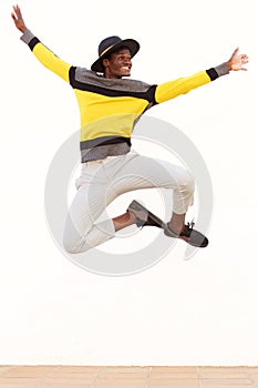 Happy young african man jumping in air over white background