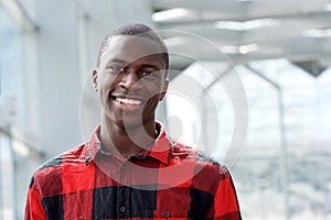 Happy young african man standing outside