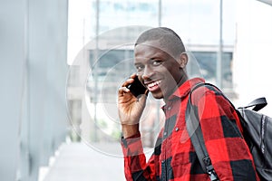 Happy young african man talking on cell phone