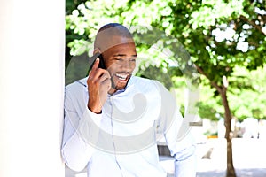 Happy young african man talking on mobile phone outdoors