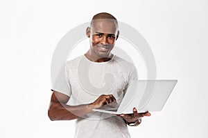 Happy young african man using laptop computer