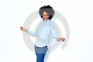 Happy young african woman dancing and enjoying against white background