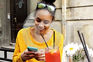 Happy young african woman sitting at cafe