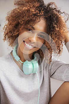 Happy young afro american woman with headphones posing to a camera.