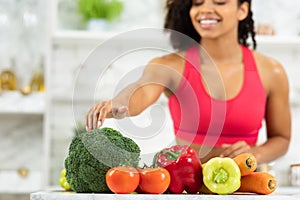 Happy young afro girl preparing vegetable salad