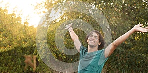 Happy young Arab man enjoying freedom under raindrops enjoying the coolness of summer at sunset. Copy space