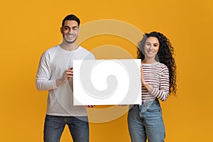 Happy Young Arab Spouses Holding White Blank Placard In Hands