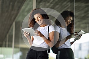 Happy young Arab woman using digital tablet in business background.