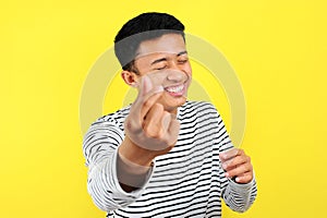 Happy young Asiam man doing finger heart, sign of love, symbol of love