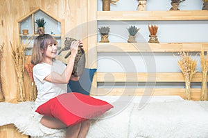 Happy young asian beautiful caucasian woman kissing and holding a  cat. Playing with pet at home. Love, coziness, leisure,