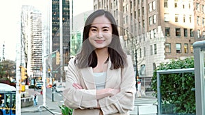 Happy young Asian business woman professional standing on big city street.