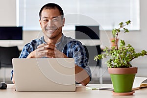 Happy young Asian entrepreneur at work in a modern office