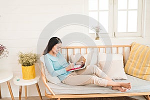 Happy young asian entrepreneur working with a laptop at home.