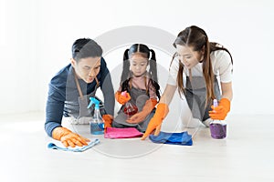 Happy young Asian family of three cleaning their home living room at weekend.Cute little helper. Family housework and household c