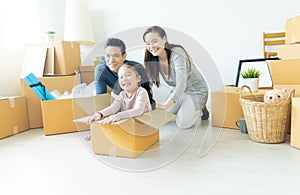 Happy young Asian family of three having fun moving with cardboard boxes in new house at moving day. Moving house day and express