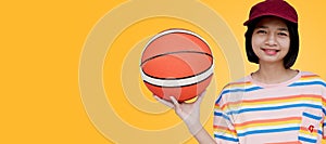 Happy young asian girl palying basketball with pastel background