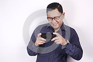 Happy Young Asian Guy Playing Games on Tablet Smart Phone