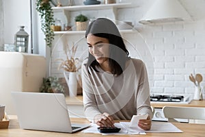 Happy young asian korean woman managing household budget.