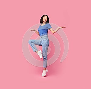 Happy young asian lady jumping at studio