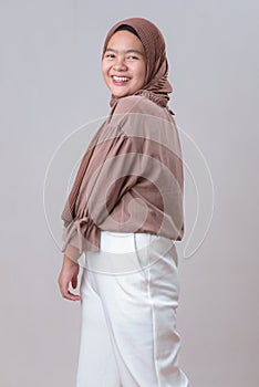 Happy Young Asian muslim model woman in hijab smiling posing  on gray