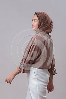 Happy Young Asian muslim model woman in hijab smiling posing isolated on gray