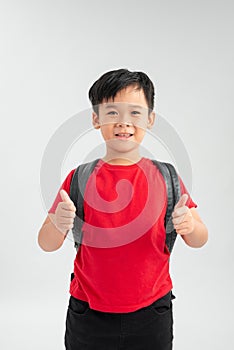 Happy young asian school boy with thumbs up isolated on a white background