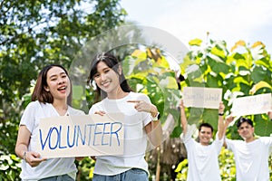 Happy young Asian students diverse volunteers with garbage bags cleaning area in the park, The concept of environmental