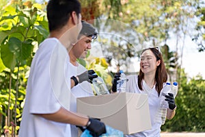 Happy young Asian students diverse volunteers with garbage bags cleaning area in the park, The concept of environmental