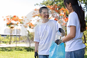 Happy young Asian students diverse volunteers with garbage bags cleaning area in the park, The concept of environmental
