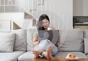 Happy young asian woman having conversation chatting while using laptop at house. Work at home, Video conference, Online