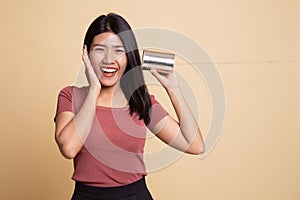 Happy Young Asian woman listen with tin can phone
