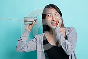 Happy Young Asian woman listen with tin can phone