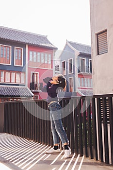 Happy young asian woman listening to music and having fun with headphones on the street.