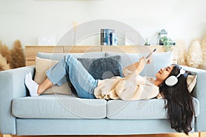 Happy young asian woman relaxing at home