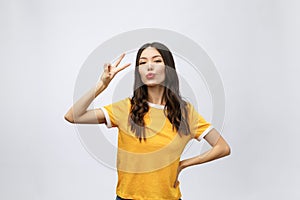 Happy young asian woman showing two fingers or victory gesture with blank copyspace area for text,Portrait of beautiful