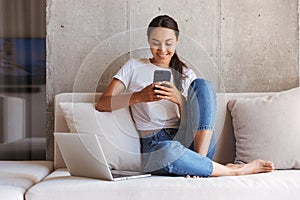 Happy young asian woman using mobile phone