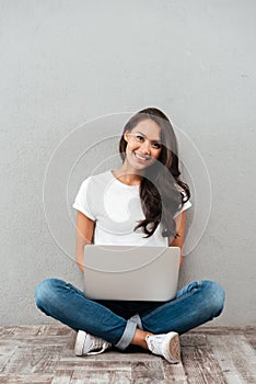 Happy young asian woman working on laptop computer