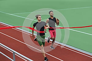 Happy young athlete man run on running track