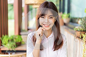 Happy young attractive asian business woman smiling at camera, standing at outdoor patio of her office