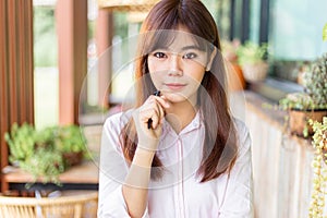 Happy young attractive asian business woman smiling at camera, standing at outdoor patio of her office