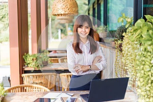 Happy young attractive asian business woman smiling at camera, standing at outdoor patio of her office