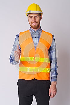 Happy young bearded man construction worker giving handshake
