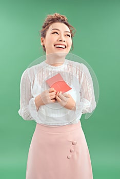 Happy young beautiful Asian girl with a love postcard valentines on green background
