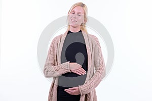 Happy young beautiful blonde pregnant woman relaxing with eyes closed