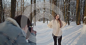 Happy young beautiful couple spend time in sunny winter forest together